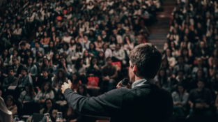 man speaking in front of crowd